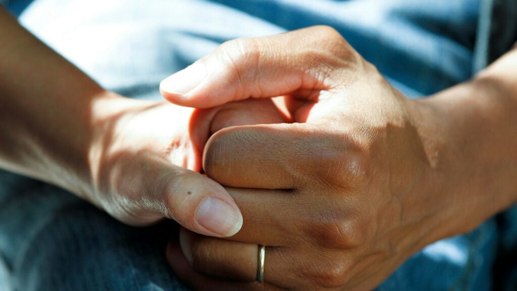 Two hands holding each other in support
