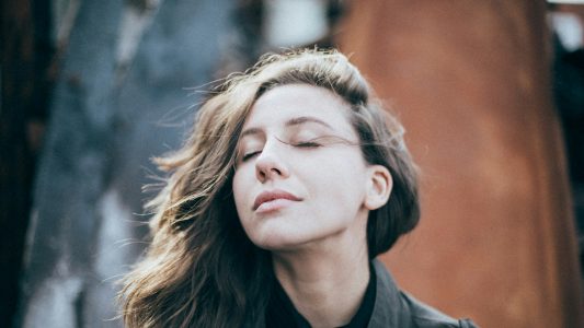 Woman with eyes closed, breathing calmly